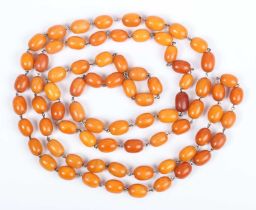 A single row necklace of seventy-six oval opaque and semitranslucent mottled butterscotch coloured