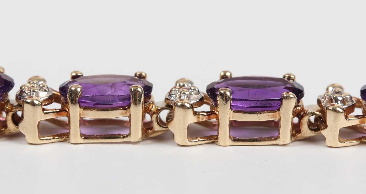 A gold and amethyst bracelet, claw set with a row of oval cut amethysts, detailed ‘10K’, on a sprung - Image 2 of 3