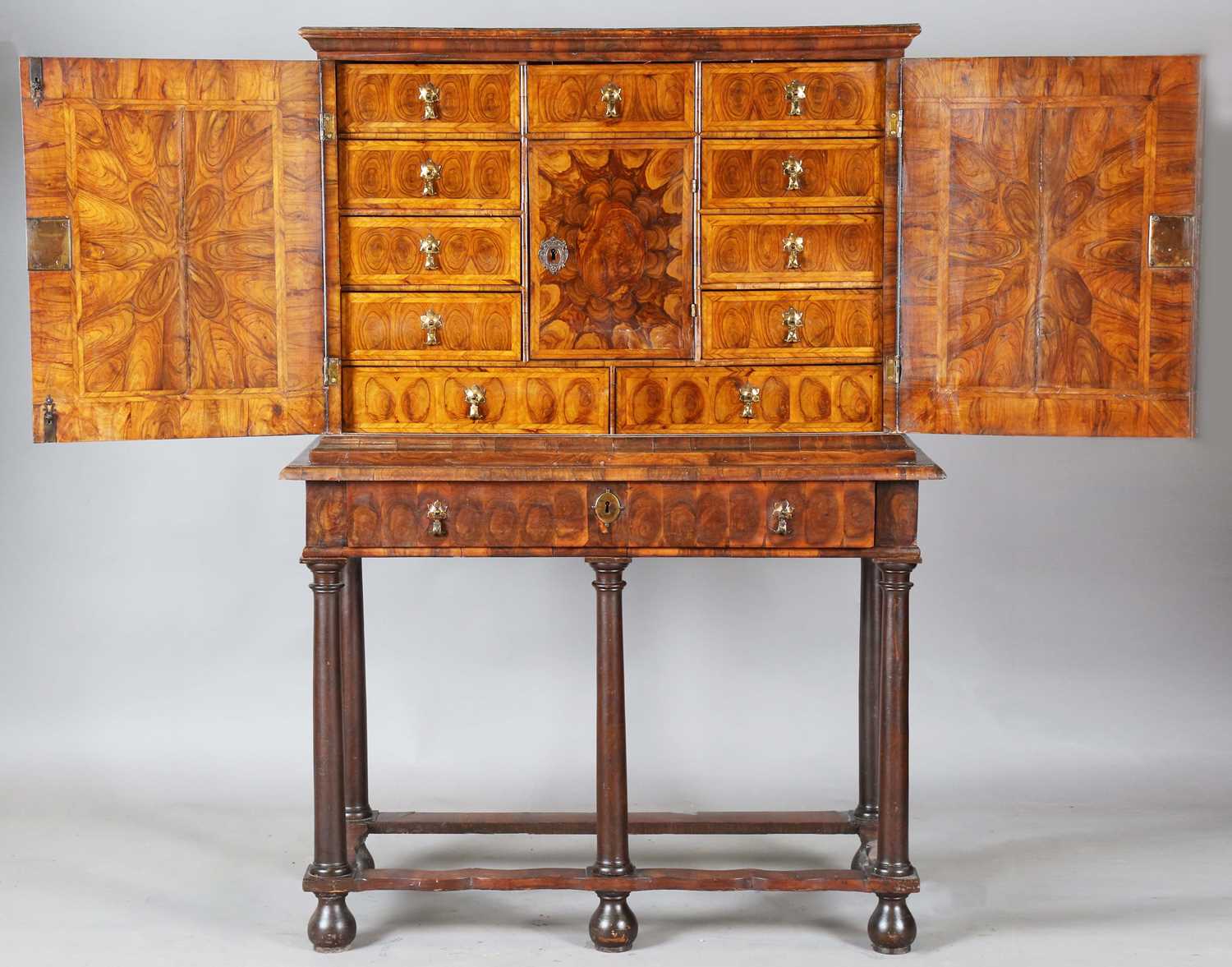 A William and Mary laburnum oyster veneered collector's cabinet-on-stand, the two doors with