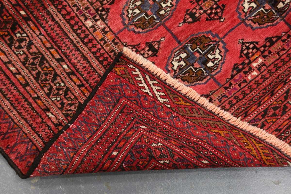 A Turkestan rug, late 20th century, the pale claret field with three columns of guls, within a - Image 7 of 7