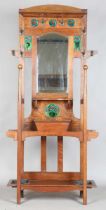 An Edwardian Arts and Crafts Glasgow School oak hallstand, the mirrored back inset with glazed