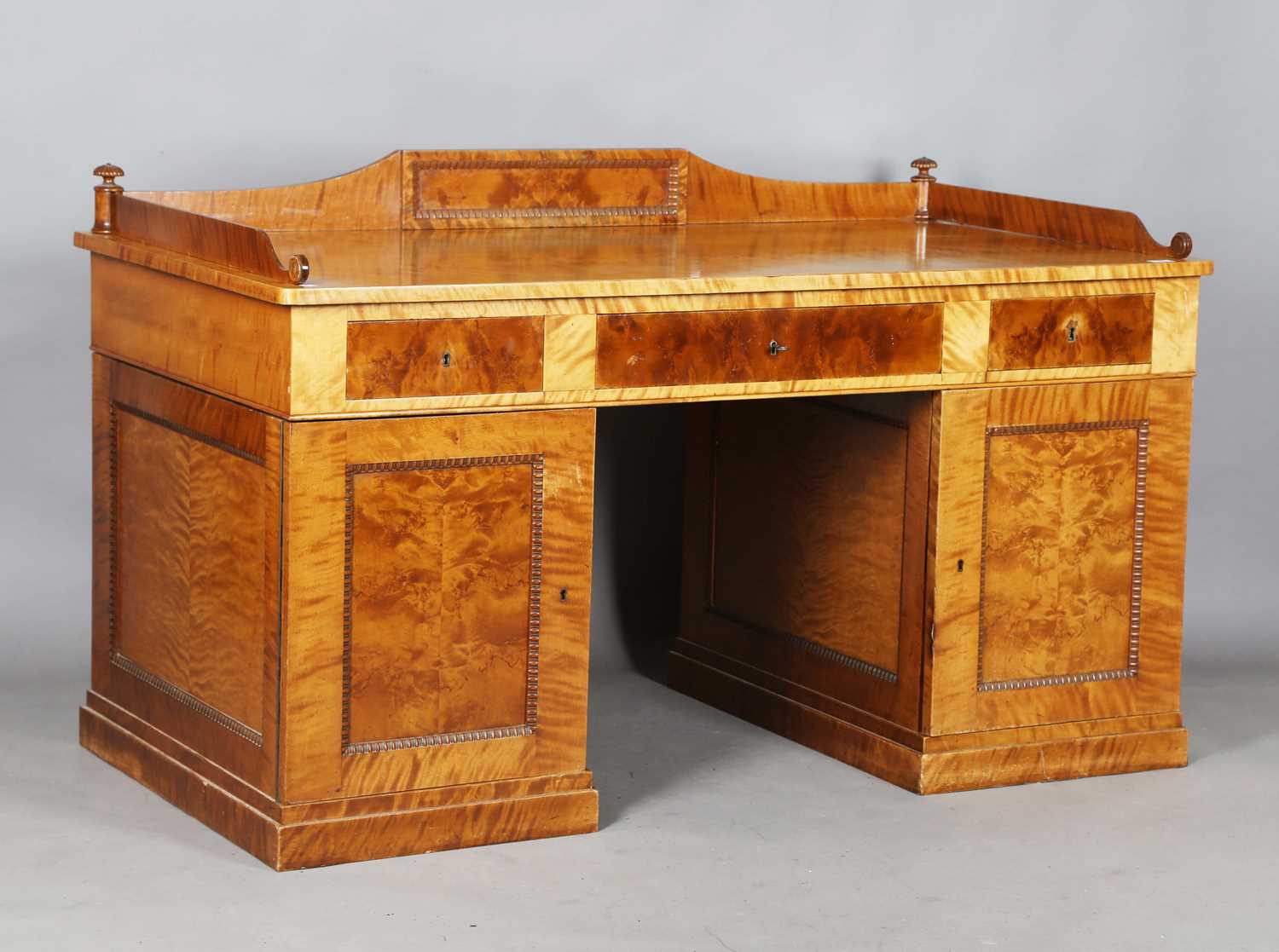 A 20th century Biedermeier style maple twin pedestal desk, the three-quarter gallery back above