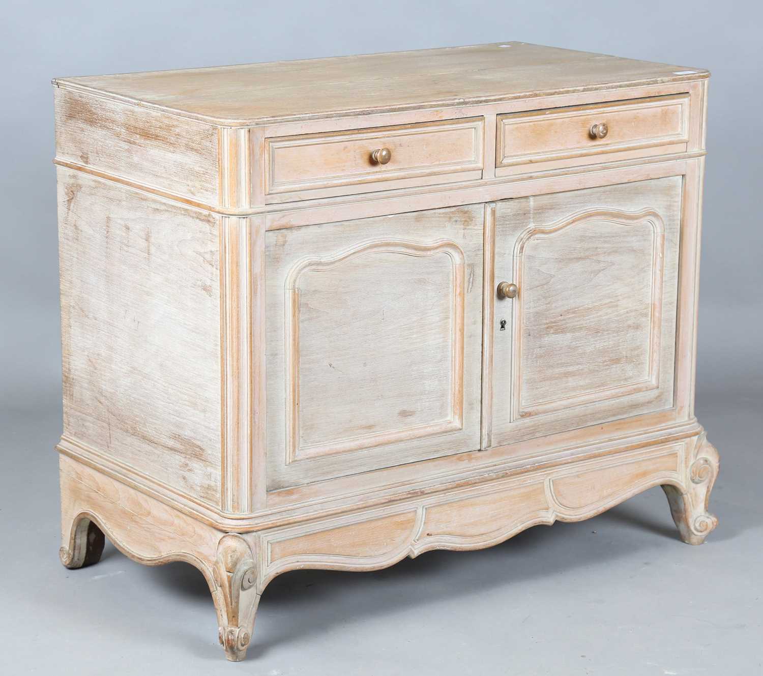 An early 20th century French limed oak side cabinet by Cauvet Frères, Paris, bearing maker's