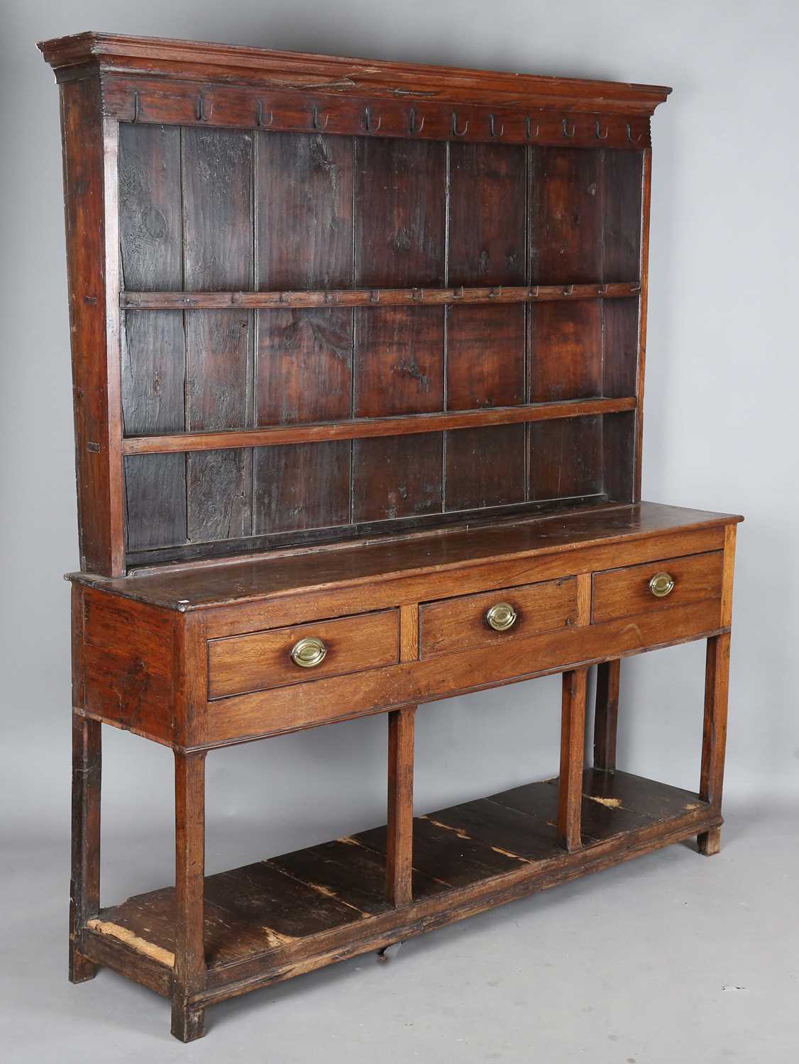 A George III provincial mahogany dresser, the plate rack above three drawers and chamfered