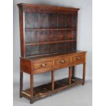 A George III provincial mahogany dresser, the plate rack above three drawers and chamfered