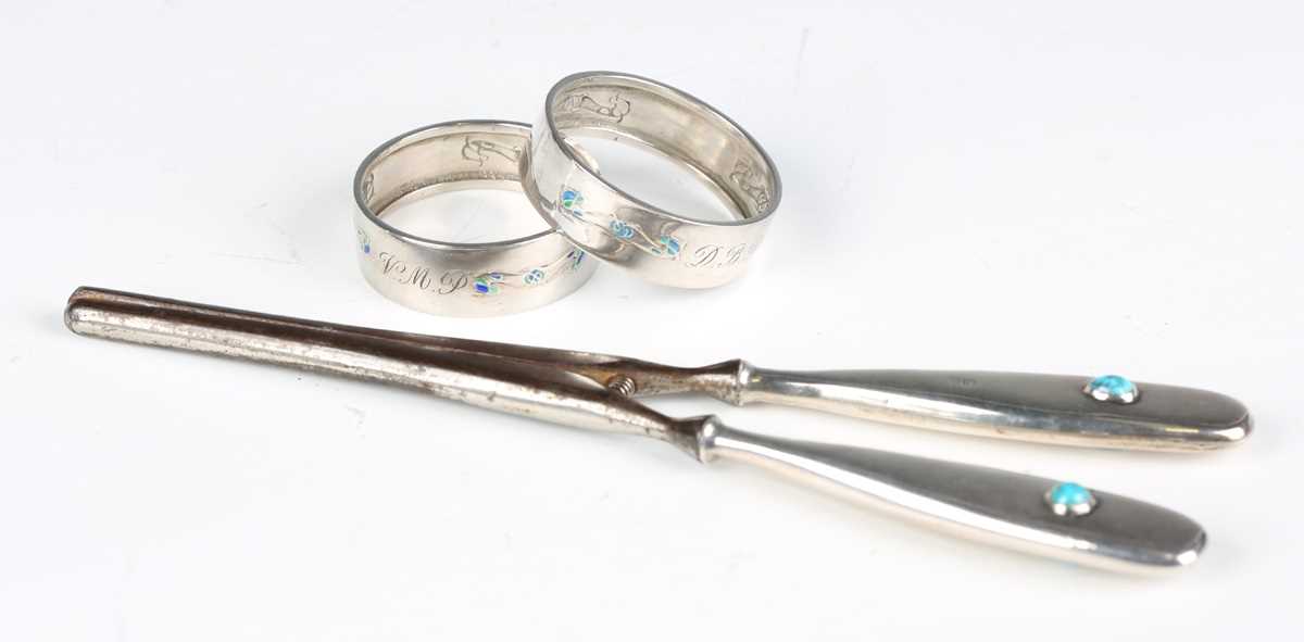 A pair of Liberty & Co 'Cymric' silver and enamelled napkin rings, Birmingham 1902, diameter 4.