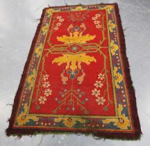 A Donegal Arts and Crafts rug, late 19th century, the red field with bold stylized plants, within