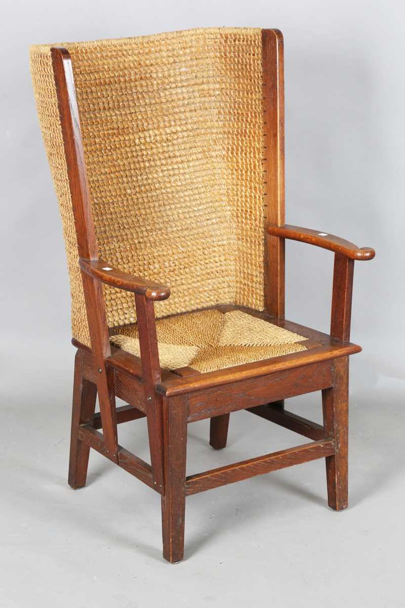 An early 20th century oak framed Orkney armchair, the curved woven straw back and string seat raised