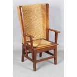 An early 20th century oak framed Orkney armchair, the curved woven straw back and string seat raised