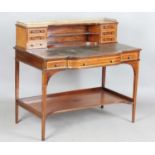 An Edwardian mahogany and satinwood crossbanded writing table, the frieze back fitted with
