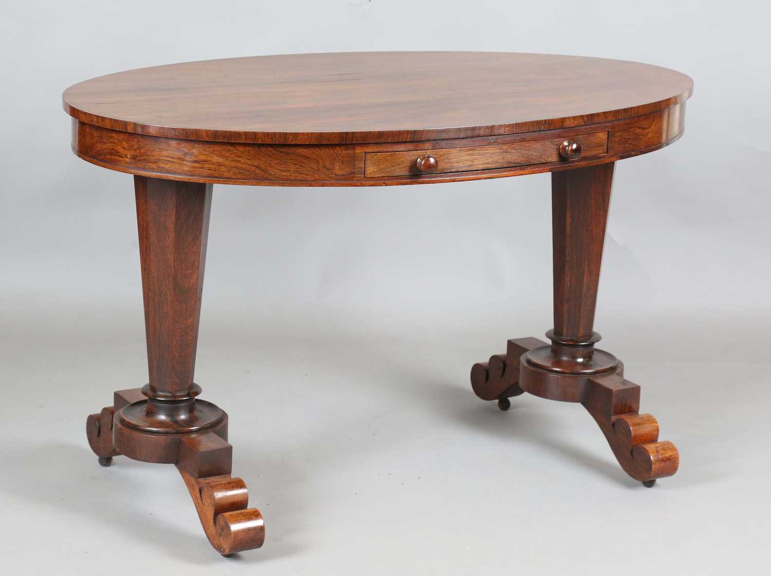 An early Victorian rosewood oval library table, fitted with opposing drawers, on octagonal