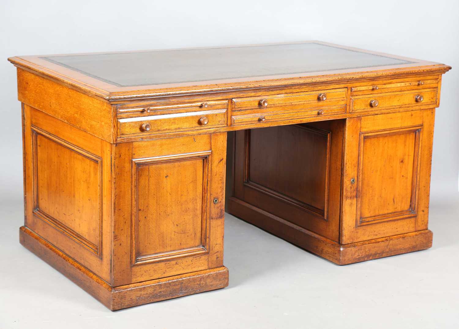 A good mid-Victorian oak twin pedestal partners desk, the moulded top inset with tooled green