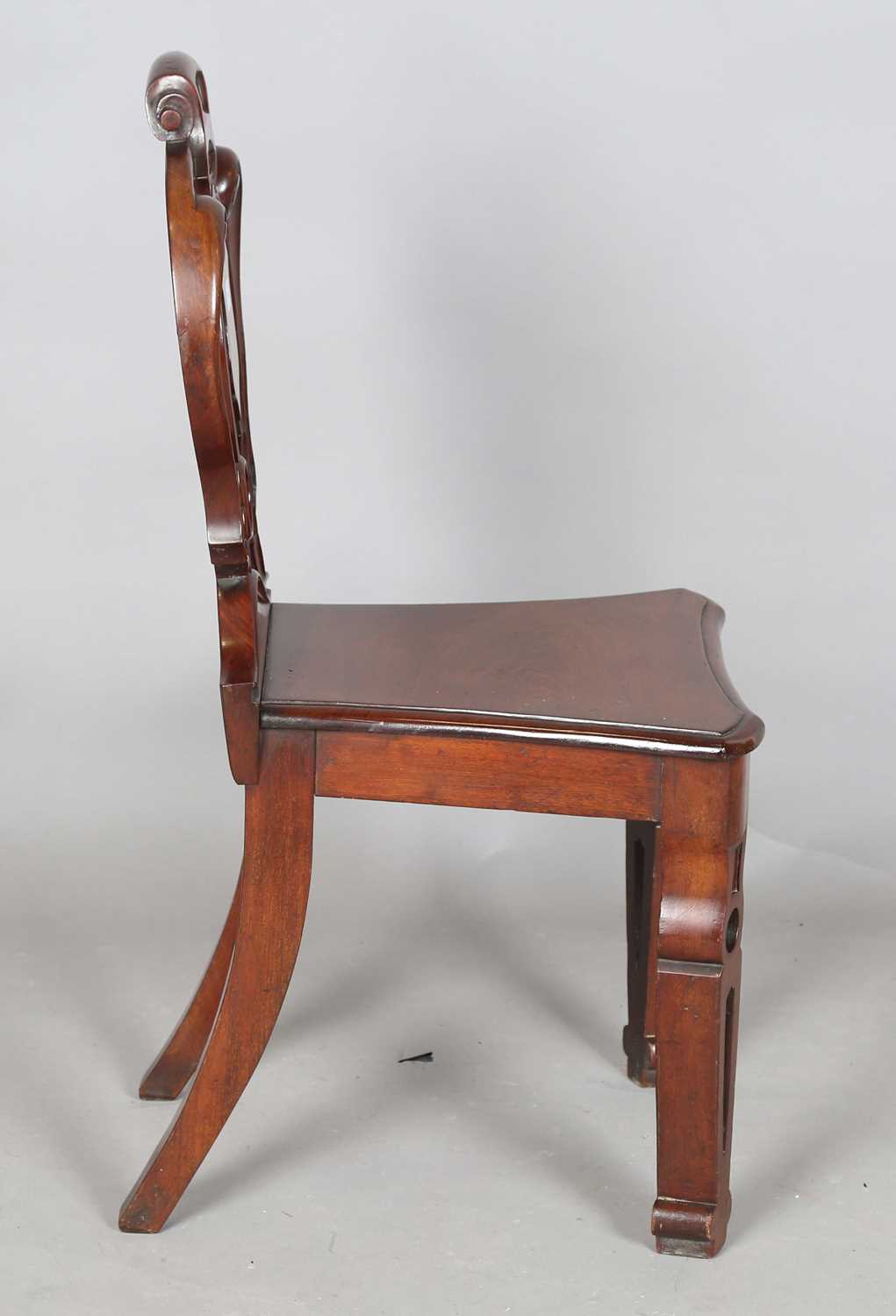 A mid-Victorian mahogany hall chair, the finely carved shield back above a solid seat, raised on - Image 5 of 8