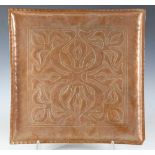 An early 20th century Arts and Crafts copper square tray, worked with overall stylized trailing