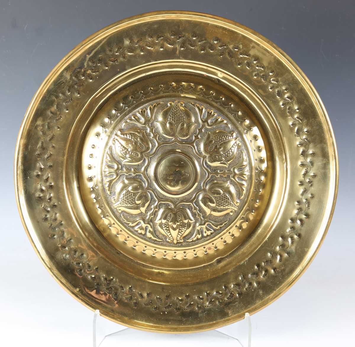 An early 20th century Arts and Crafts brass charger, the centre finely worked with a band of