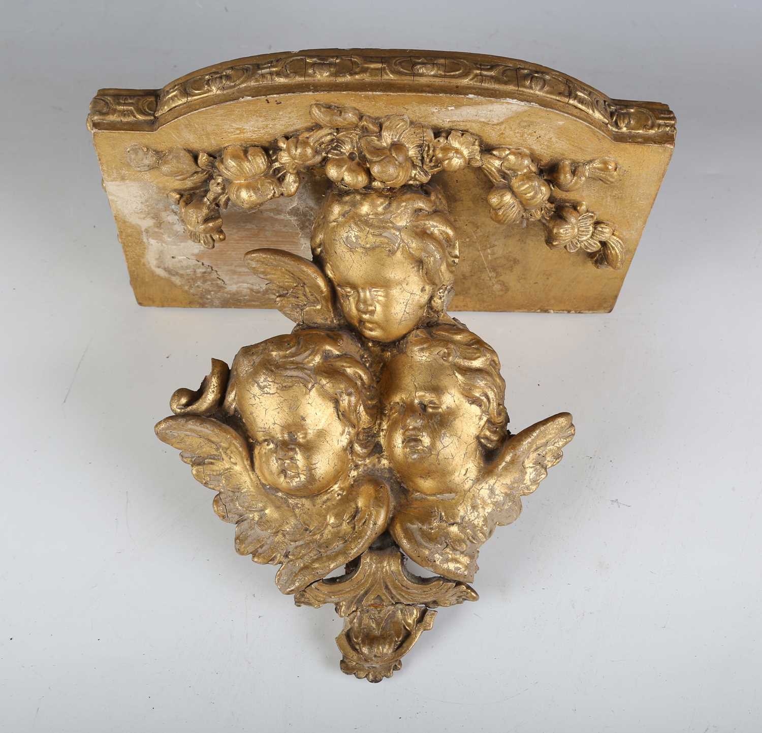 A late 19th century composition wall bracket with a triple cherub mask support, height 23cm, width