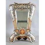 A French Art Nouveau silvered and painted dressing table mirror of shaped outline, decorated with