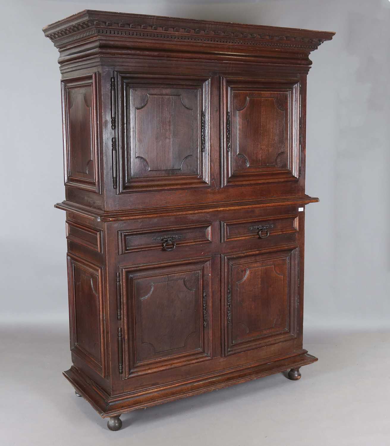 A large 18th century Continental oak cupboard, fitted with four panelled doors and two drawers,