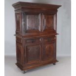 A large 18th century Continental oak cupboard, fitted with four panelled doors and two drawers,