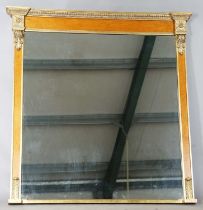 A 20th century reproduction maple and giltwood overmantel mirror with rosette and scroll