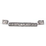 An Arts and Crafts silver rectangular bar brooch, decorated in relief and hammered with stylized