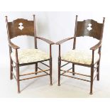 A pair of early 20th century Arts and Crafts oak and ash framed elbow chairs, in the manner of