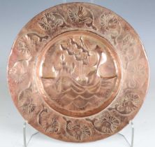 A Newlyn style copper circular charger, worked with a central galleon within a border of fish,