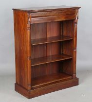 A 20th century reproduction hardwood open bookcase with turned pilasters and a single frieze drawer,