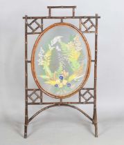 A late Victorian Aesthetic Movement bamboo framed firescreen, the central glazed panel with a