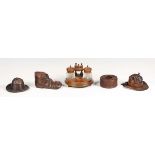 A group of five mainly late 19th century carved treen inkwells, two carved as hats, one in the