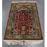 A Kashmir part silk prayer rug, late 20th century, the red mihrab with ascending flower-filled vase,
