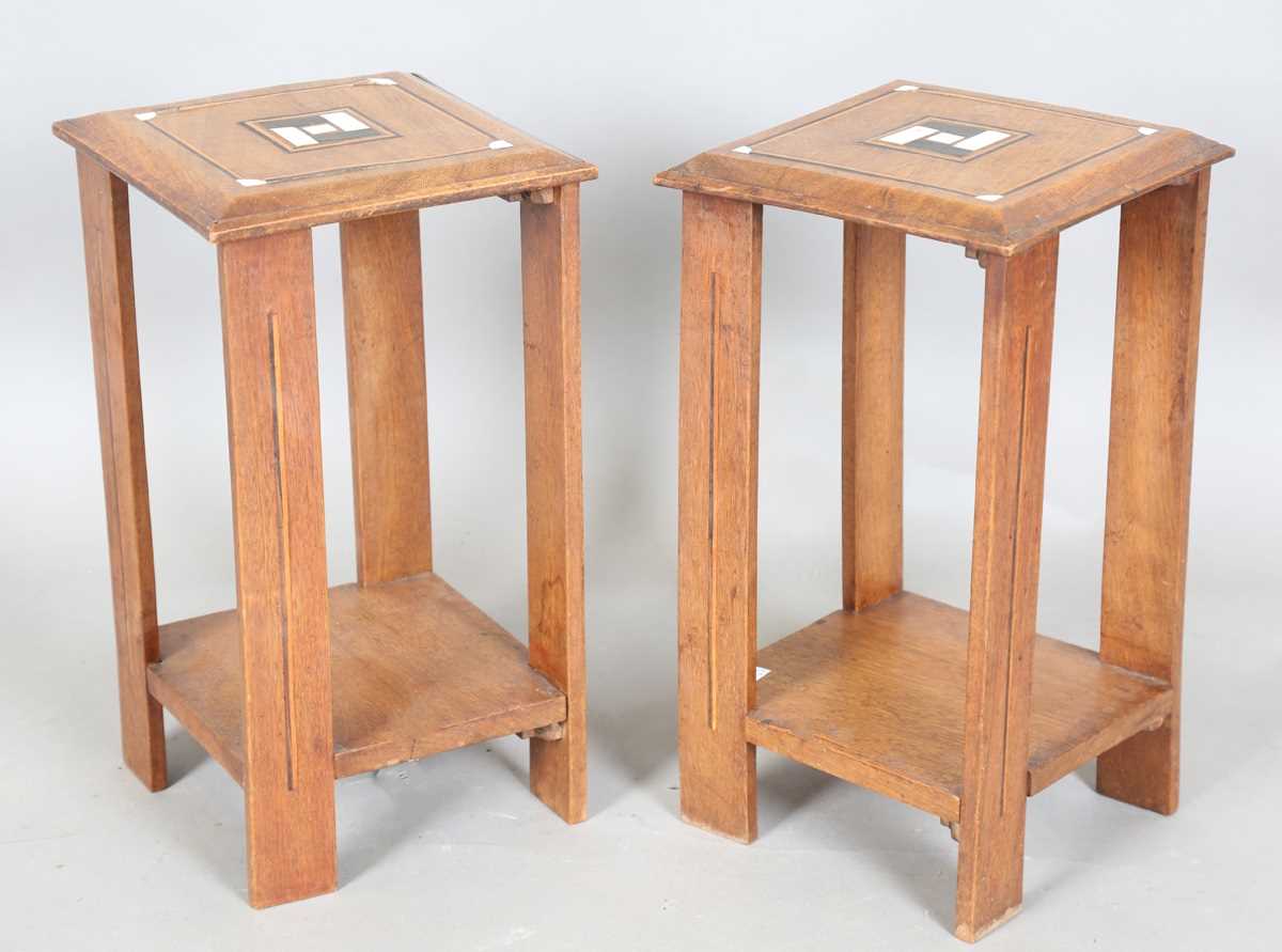 A pair of early 20th century Arts and Crafts walnut two-tier occasional tables, both stamped '