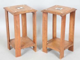 A pair of early 20th century Arts and Crafts walnut two-tier occasional tables, both stamped '