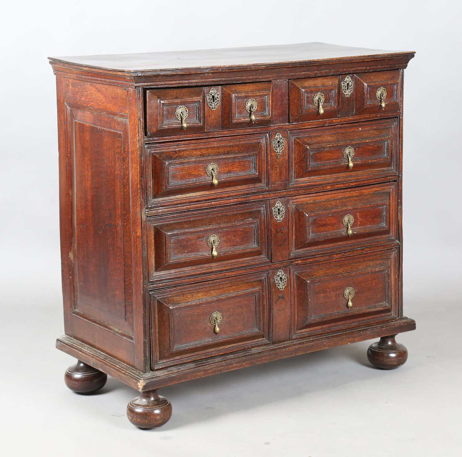 A William and Mary oak chest of two short and three long drawers, all with deep geometric