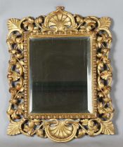 An early 20th century Continental giltwood wall mirror with a carved foliate frame and bevelled