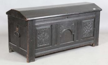 An 18th century panelled oak coffer with a domed lid and carved front, height 61cm, width 125cm,