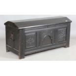 An 18th century panelled oak coffer with a domed lid and carved front, height 61cm, width 125cm,