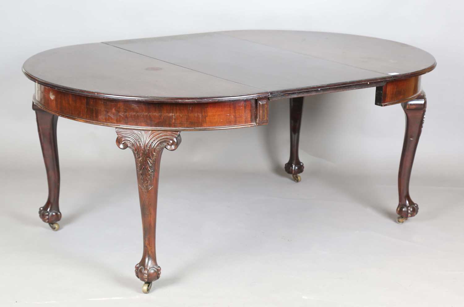 An early 20th century mahogany extending dining table, the circular top with single extra leaf,