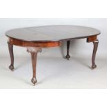 An early 20th century mahogany extending dining table, the circular top with single extra leaf,