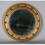 A 20th century gilt painted circular wall mirror with a ballshot border and bevelled glass, diameter