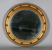 A 20th century gilt painted circular wall mirror with a ballshot border and bevelled glass, diameter