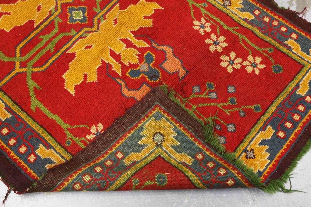 A Donegal Arts and Crafts rug, late 19th century, the red field with bold stylized plants, within - Image 6 of 6