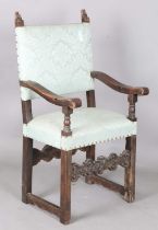 A late 17th century Continental walnut armchair, the finials carved with masks, the two front legs