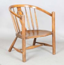 An early 20th century Arts and Crafts ash and elm tub back armchair with a pierced star splat