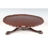 An early 20th century George III style mahogany lazy Susan with a piecrust edge and tripod legs,