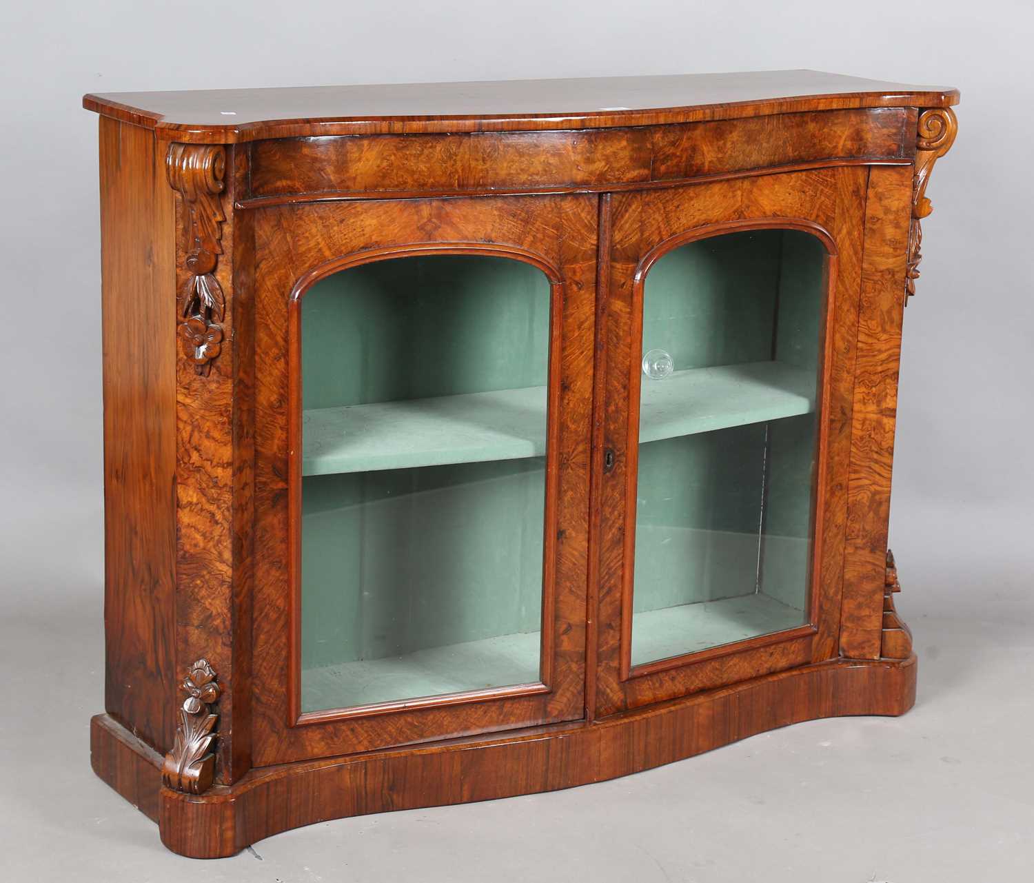 A mid-Victorian burr walnut serpentine fronted glazed bookcase with projecting corners, height 91cm,