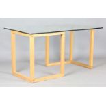 A modern rectangular glass-topped table with a pair of oak 'L' shaped supports, height 73cm,