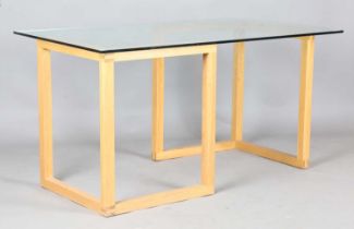 A modern rectangular glass-topped table with a pair of oak 'L' shaped supports, height 73cm,