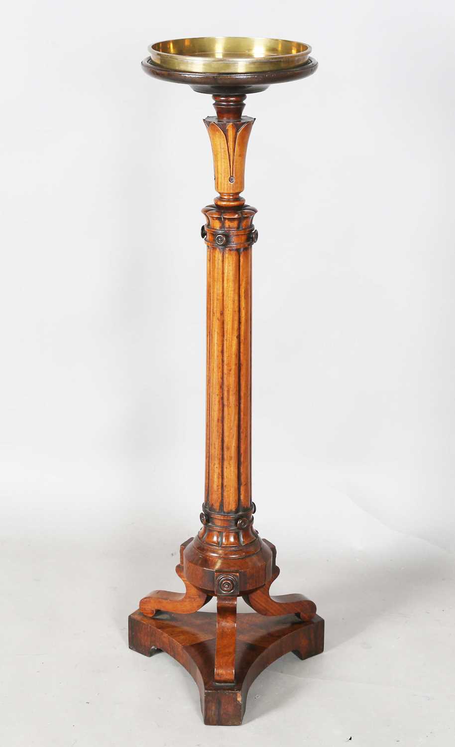 A William IV mahogany torchère, the top fitted with a brass tray above a reeded stem and triform