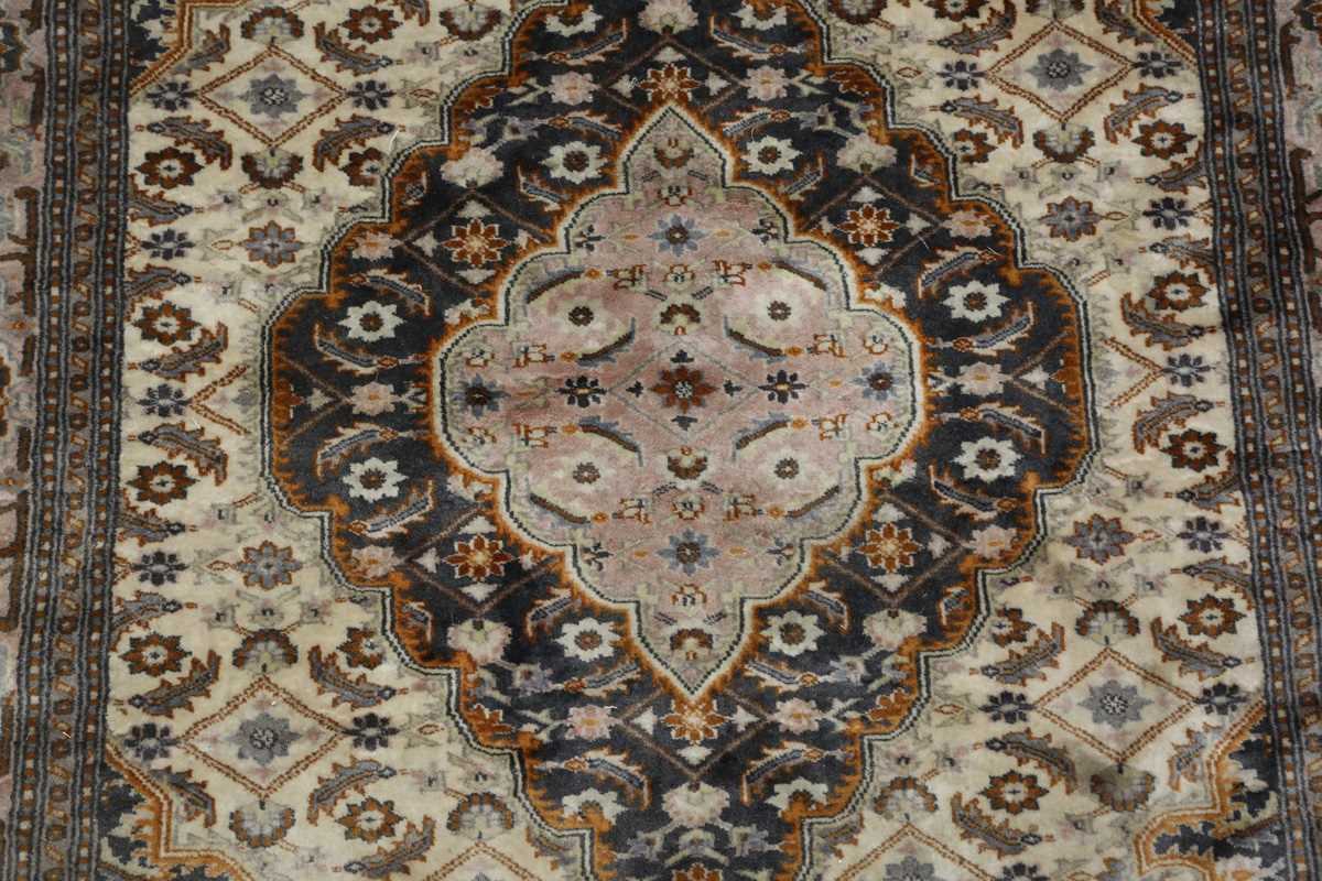 A Kashmir rug, signed, late 20th century, the cream field with a shaped medallion, within a palmette - Image 3 of 6